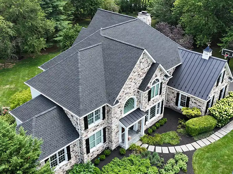 Large home with metal roof and new gray shingles